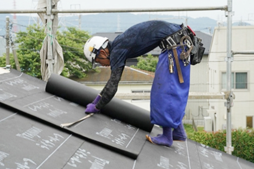 屋根施工をする社員